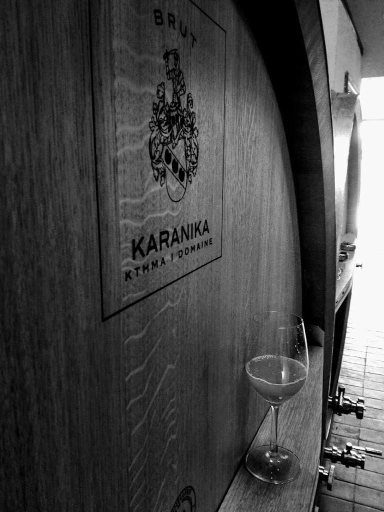 personalized wooden wine barrels sign says 'KARANIKA KTHMA I DOMAINE' logo into the cellar